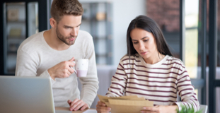 Young couple paying bills to rebuild credit after bankruptcy